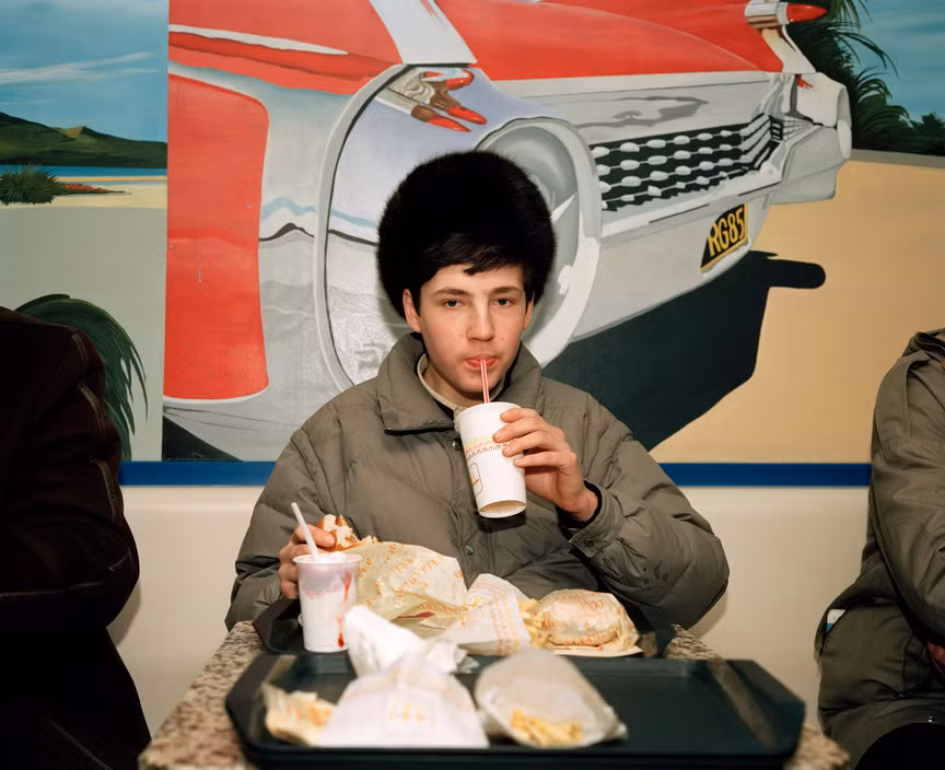 Một thanh niên thưởng thức đồ ăn Mc Donalds. Ảnh: Martin Parr/ Magnum Photos.