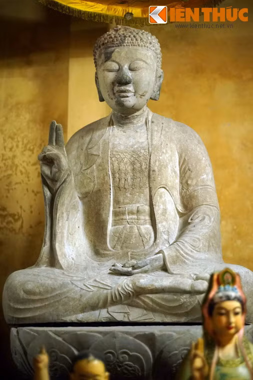 Tượng bên phải đượng tạo tác tương tự pho ở giữa, nhưng có đôi chút khác biệt trong tư thế ngồi thiền, thế tay kết ấn. Áo cũng có ba lớp, lớp ngoài choàng qua vai, lớp trong choàng kín người để hở cổ và ngực đeo dây anh lạc, trước bụng thắt “con ro”.