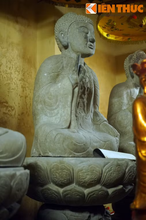 Bức tượng ở giữa được tạc trong tư thế ngồi thiền“bán kiết già” trên toà sen, tay phải giơ lên trong tư thế kết ấn, tay trái để úp nhẹ nhàng trên đùi trái. Tượng vận pháp y với ba lớp mềm mại: Lớp ngoài choàng qua bờ vai, lớp trong phủ kín toàn thân, lớp trong cùng phía trên để hở ngực đeo dây anh lạc.