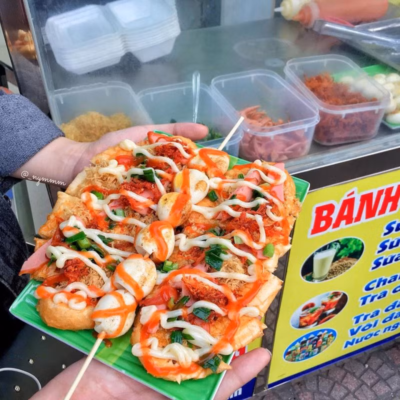 Bánh mì phết mật ong, nướng cùng chà bông, mỡ hành, xúc xích, bò khô, trứng chim cút sau đó rưới lên một lớp sốt béo béo, ngậy ngậy, cay cay. Chắc chắn ai đã ăn một lần không thể cưỡng lại được sự hấp dẫn của món ăn này.