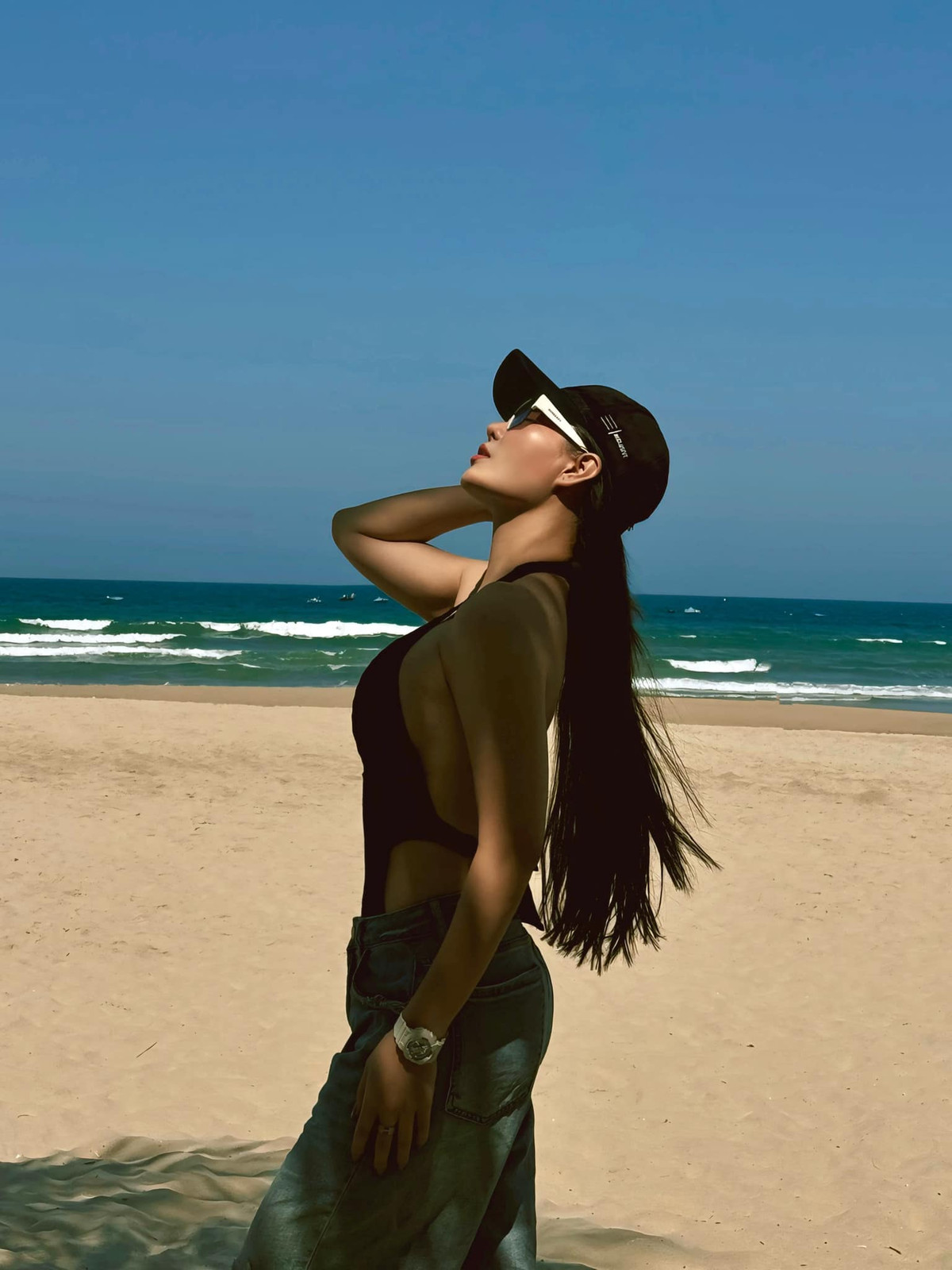 Nữ diễn viên tạo dáng đa dạng trên bờ biển, lúc nằm dài trên cát, lúc đùa nghịch với sóng nước, lúc lại thả dáng bước đi đầy thần thái.