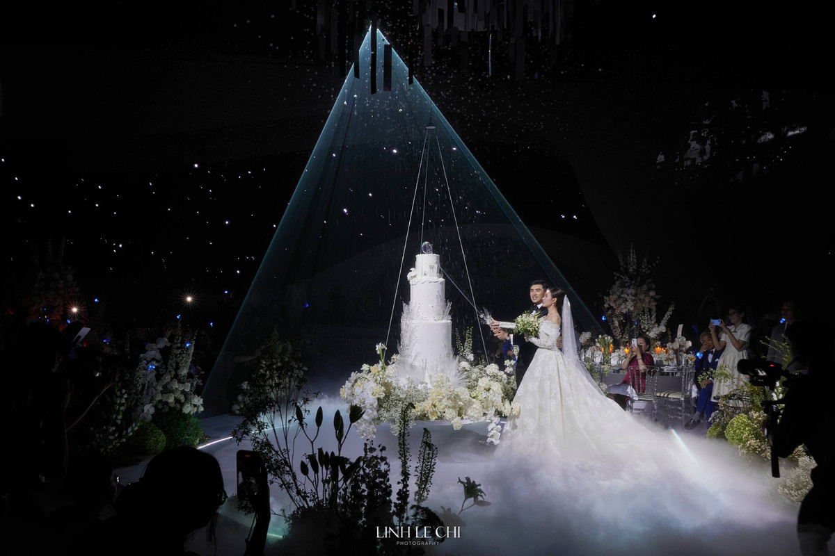 Chi tiết đặc biệt thu hút sự chú ý nhất trong hôn lễ chính là màn cắt bánh cưới độc đáo của Midu và Minh Đạt.