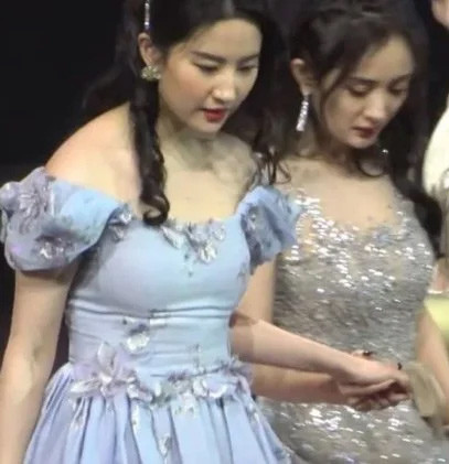 Lưu Diệc Phi to hơn hẳn Dương Mịch khi hai người cùng dắt tay nhau trong một sự kiện. (Ảnh: Sina)