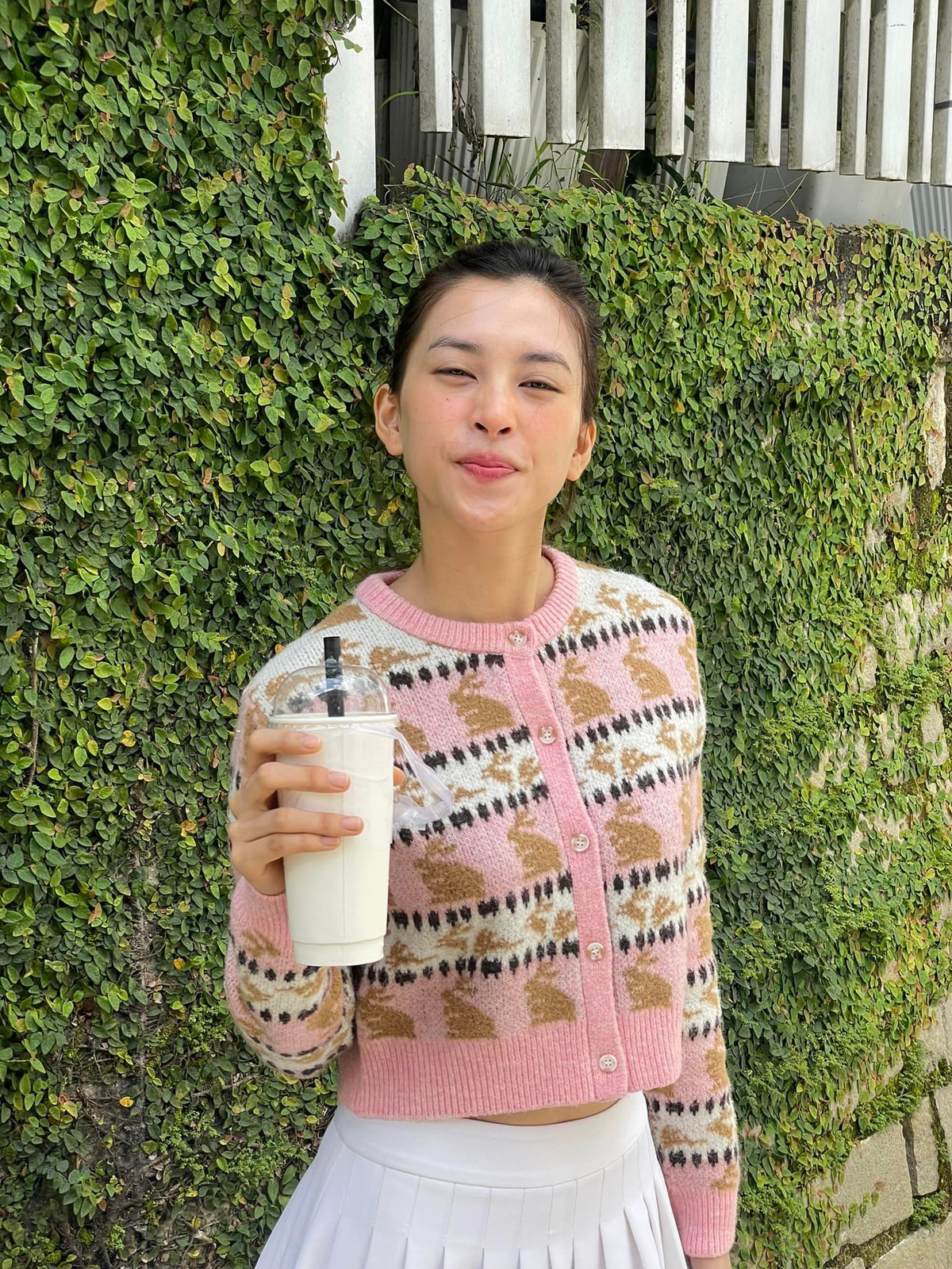 Hoa hậu Tiểu Vy dạo chơi trên phố, tạo dáng với cốc nước. Ảnh: FB Trần Tiểu Vy