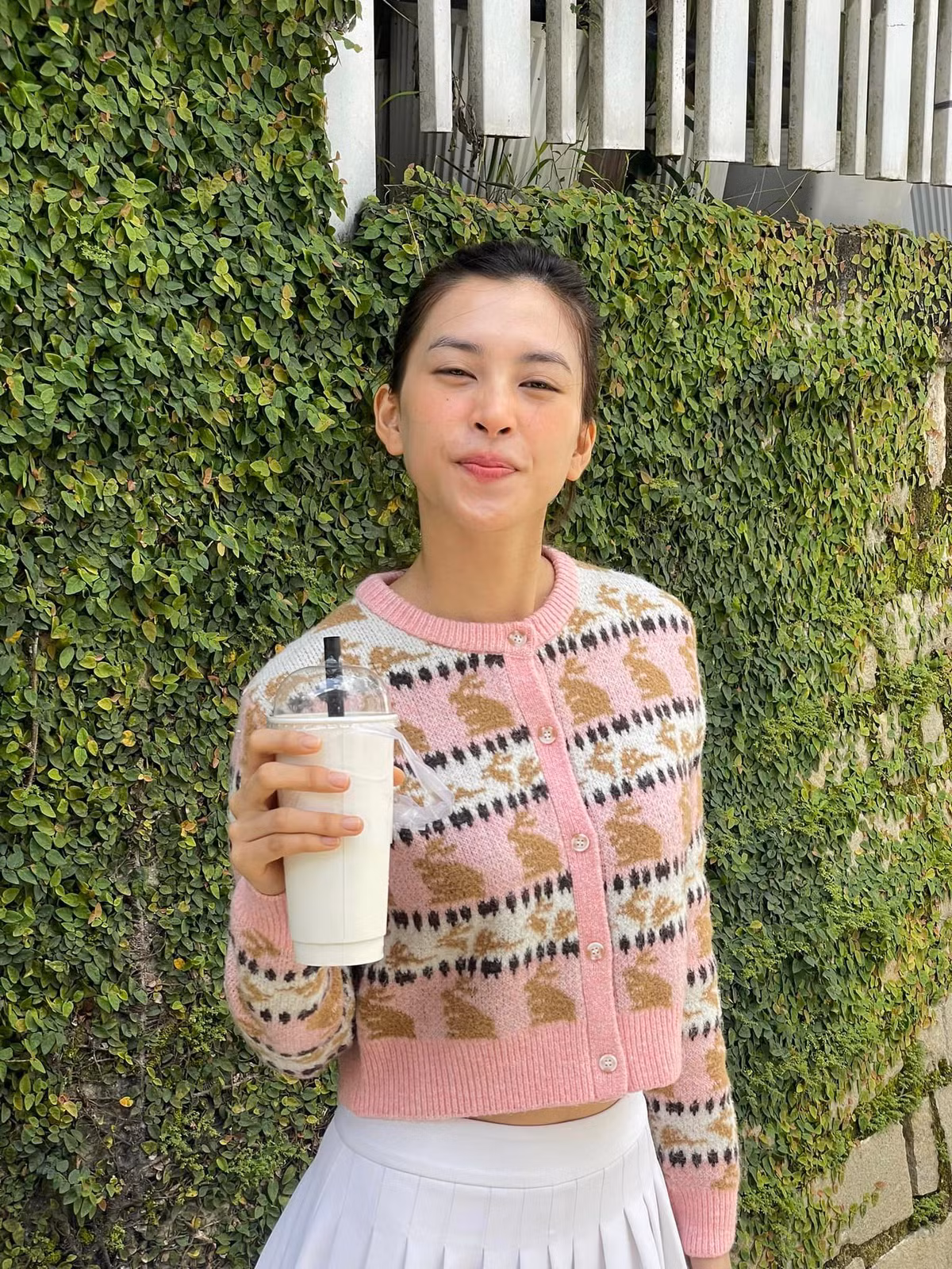 Hoa hậu Tiểu Vy dạo chơi trên phố, tạo dáng với cốc nước. Ảnh: FB Trần Tiểu Vy