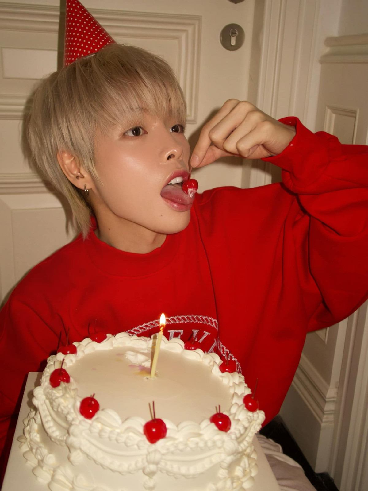 Ca sĩ Đức Phúc mặc áo đỏ rực rỡ, cầm bánh chúc mừng sinh nhật. Ảnh: FB Đức Phúc