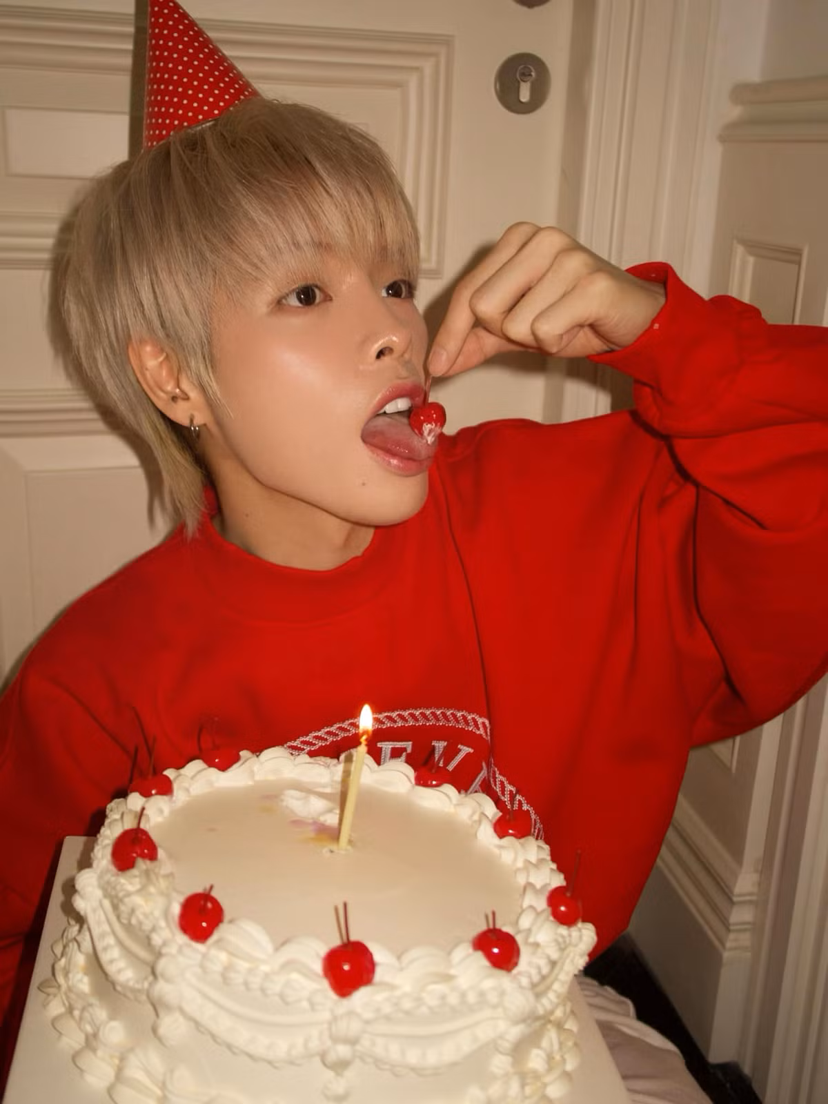 Ca sĩ Đức Phúc mặc áo đỏ rực rỡ, cầm bánh chúc mừng sinh nhật. Ảnh: FB Đức Phúc