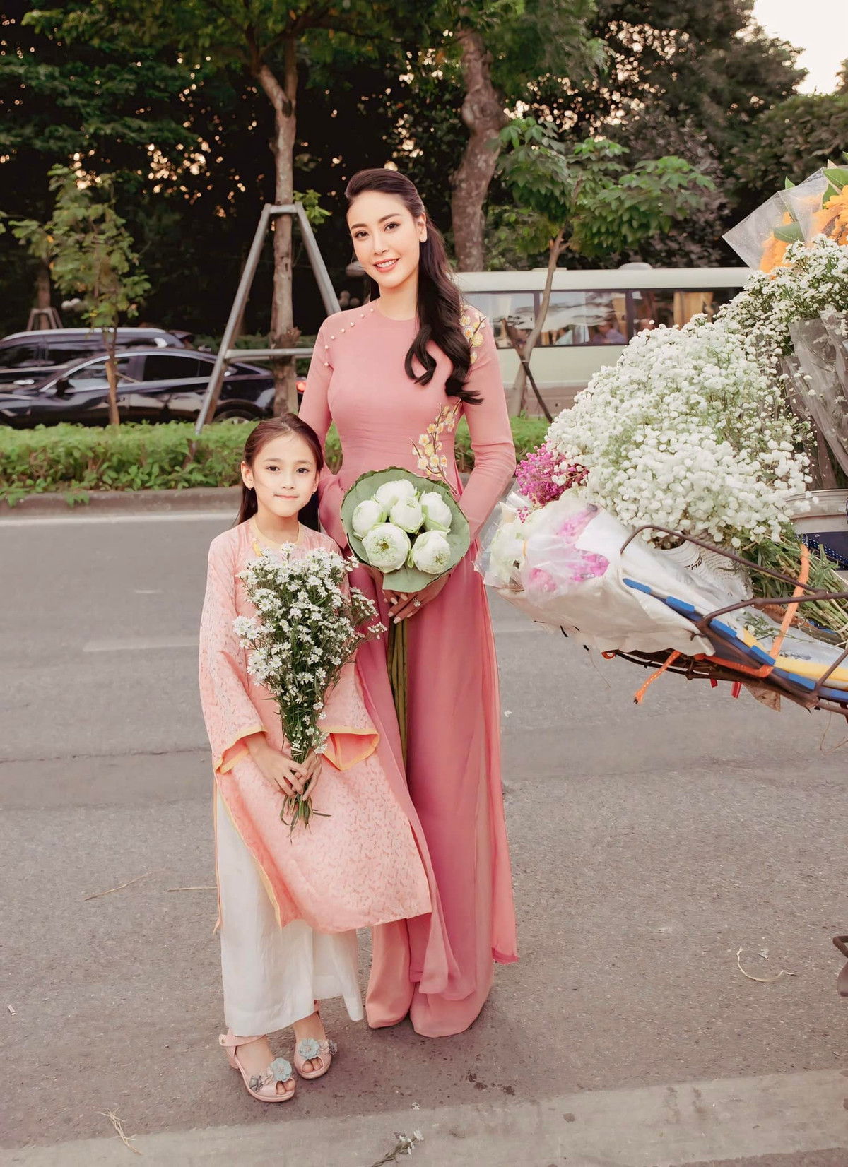 Hà Kiều Anh và con gái Viann diện áo dài hồng pastel nữ tính, chụp hình cùng hoa mùa thu. Ảnh: FB Ha Kieu Anh