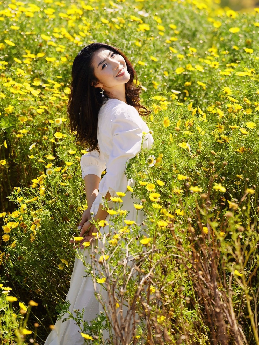 Siêu mẫu Ngọc Quyên chụp ảnh giữa đồi hoa vàng.