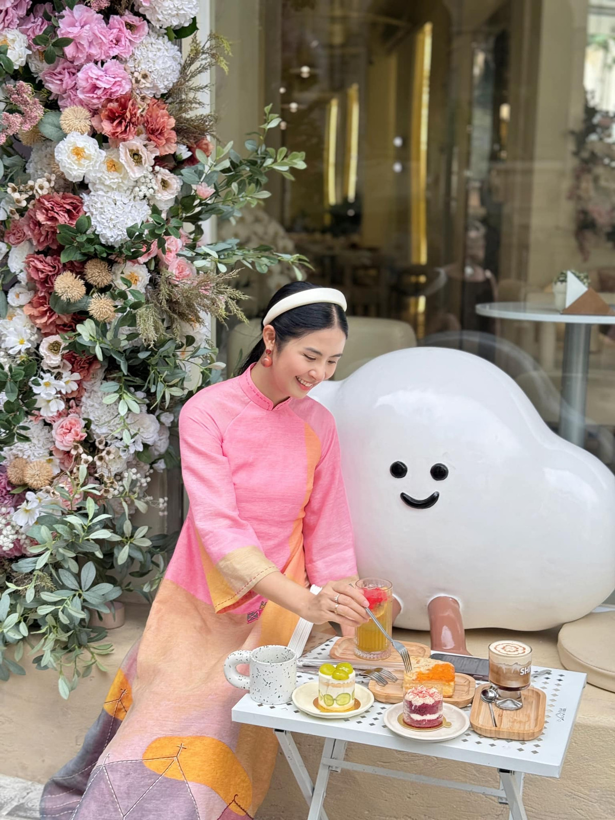 Hoa hậu Ngọc Hân mặc áo dài, ngồi nhâm nhi bánh và trà. Ảnh: FB Ngoc Han Dang