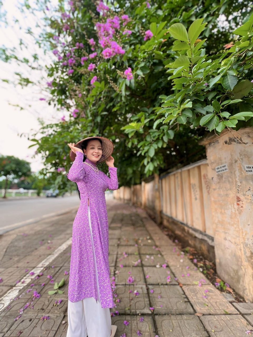 Diễn viên Chiều Xuân diện áo dài tím, chụp ảnh bên hoa bằng lăng.
