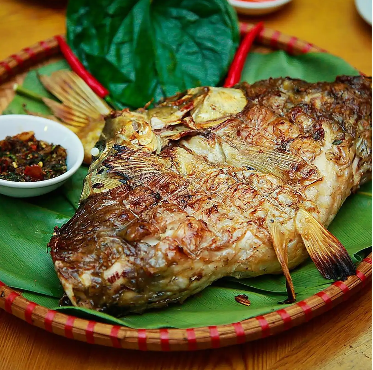 Pa pỉnh tộp là món ăn đặc sản Điện Biên khiến nhiều du khách lạ lẫm. Đây thực chất là cá suối nướng, cá tẩm ướp gia vị rồi nướng trên than hồng, mang đến hương vị thơm nức mũi. Ảnh: Vietnamnet