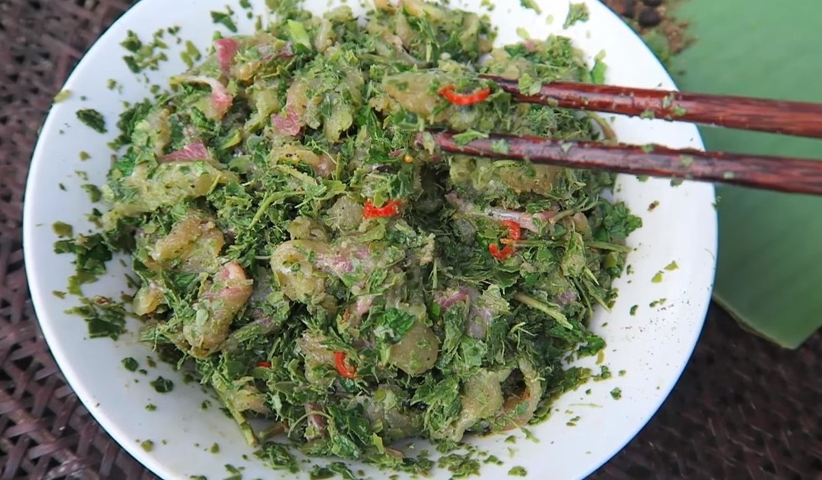 Cho các nguyên liệu trên vào cá đã thái miếng mỏng và trộn đều, rắc thêm chút muối, thính gạo và thêm chút nước rồi đảo đều. Lá chát và thính gạo sẽ làm thịt cá chiên chín tái và chuyển sang màu trắng. Đến lúc đó là có thể thưởng thức món gỏi cá chiên sông Đà. Vị ngọt mềm, giòn sần sật tự nhiên của cá chiên hòa quyện với vị chan chát của lá rừng, thơm nồng của mắc khén, hạt dổi và vị cay của ớt khiến người ăn nhớ mãi. Ảnh HoabanFood