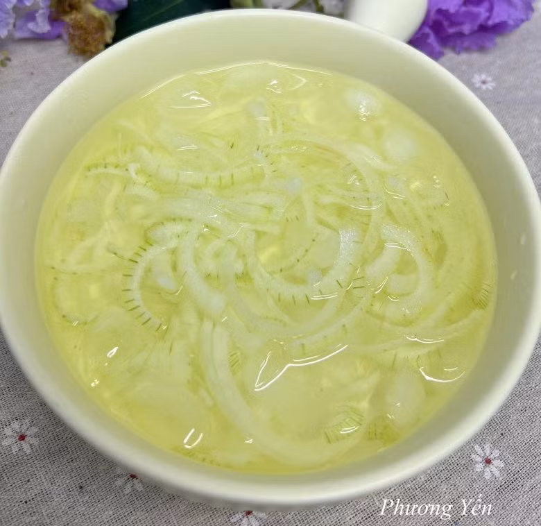 Hành tây bóc vỏ, thái mỏng rồi cho ngay vào bát nước đá ngâm cho bớt hăng. Ảnh: Phương Yến