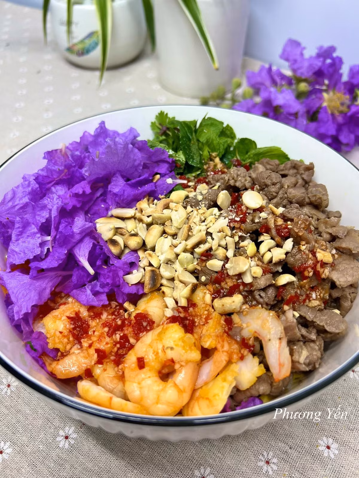 Nguyên liệu để làm món ăn hot trend này gồm: cánh hoa bằng lăng rửa sạch, thịt bò, tôm sú, xoài xanh, cà rốt, hành tây, ớt chuông. Rau thơm: húng lủi, rau mùi, tía tô, húng quế. Gia vị: nước mắm, đường, chanh, tỏi, ớt, tiêu, dầu ăn. Ảnh: Phương Yến