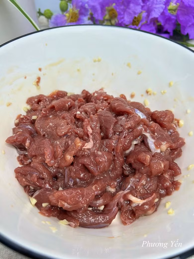 Thịt bò: Rửa sạch, thái mỏng và ướp với 1 muỗng cà phê hạt nêm, 1 muỗng cà phê nước mắm, 1 muỗng cà phê dầu hào, 1 muỗng cà phê tỏi băm, 1/2 muỗng cà phê tiêu trong 15 phút. Ảnh: Phương Yến