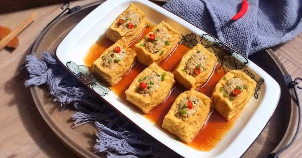  Đậu phụ nhồi hàu: 4 miếng đậu phụ, 200g thịt hàu, 100g thịt xay, 5 củ hành tím, 1 củ tỏi, rau xà lách, rau thơm, nước tương, bột nêm, tiêu, dầu ăn, dầu hào. Sơ chế nguyên liệu. Đậu phụ cắt vuông, khoét lỗ bên trên. Hành tím, tỏi băm nhuyễn. Hàu thái hạt lựu nhỏ. Trộn đều thịt xay, hàu và gia vị. Nhồi nhân vào đậu phụ. Chiên đậu vàng đều rồi vớt ra để ráo. Dùng chung với rau xà lách, rau thơm và nước tương. Ảnh Internet