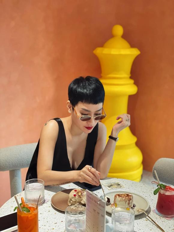 Mẹ 2 con Trà My chụp hình thưởng thức món bánh ngọt.