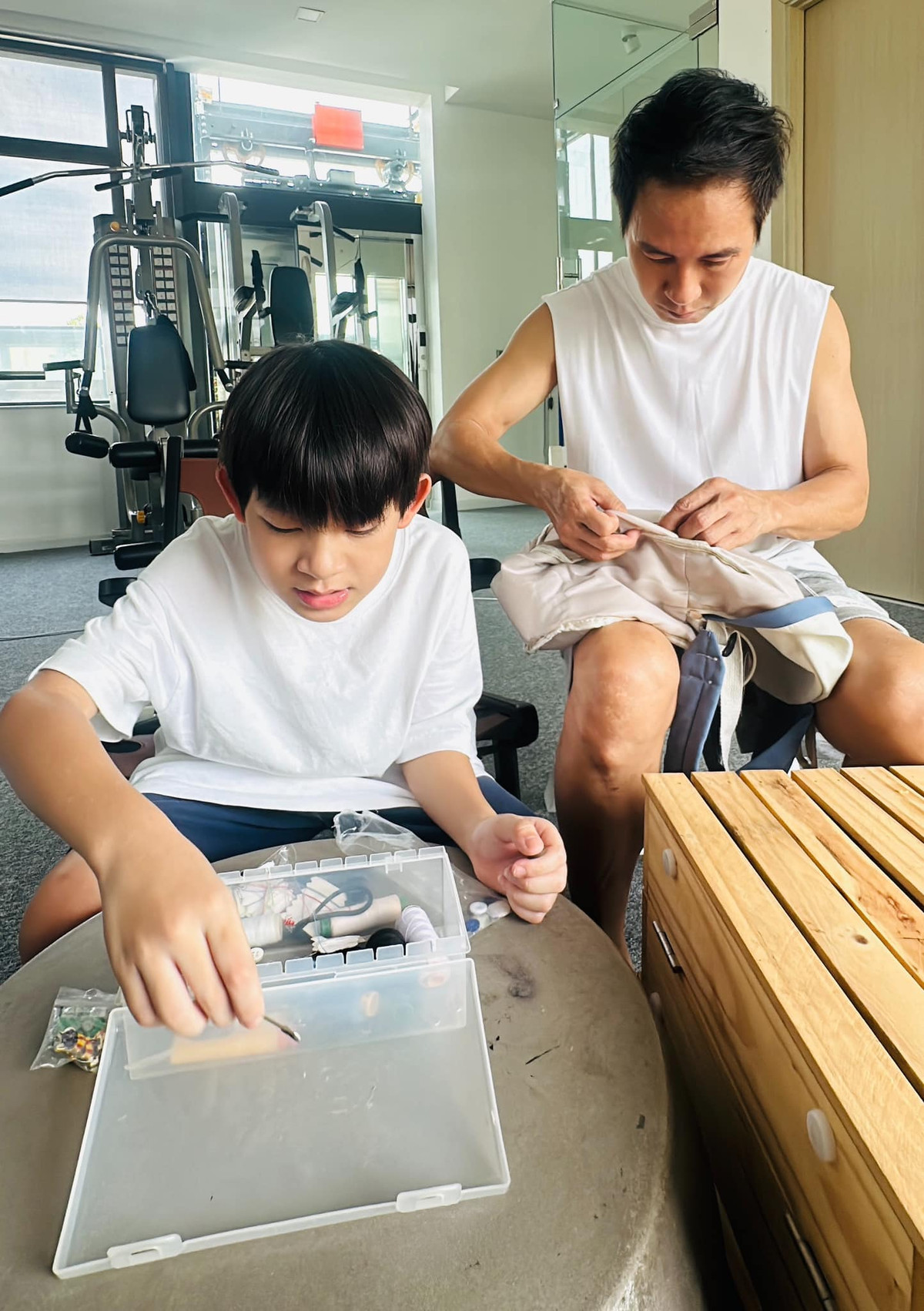 Minh Hà ghi lại khoảnh khắc ông xã Lý Hải cặm cụi sửa cặp cho con trai. Ảnh: FB Ly Hai Minh Ha