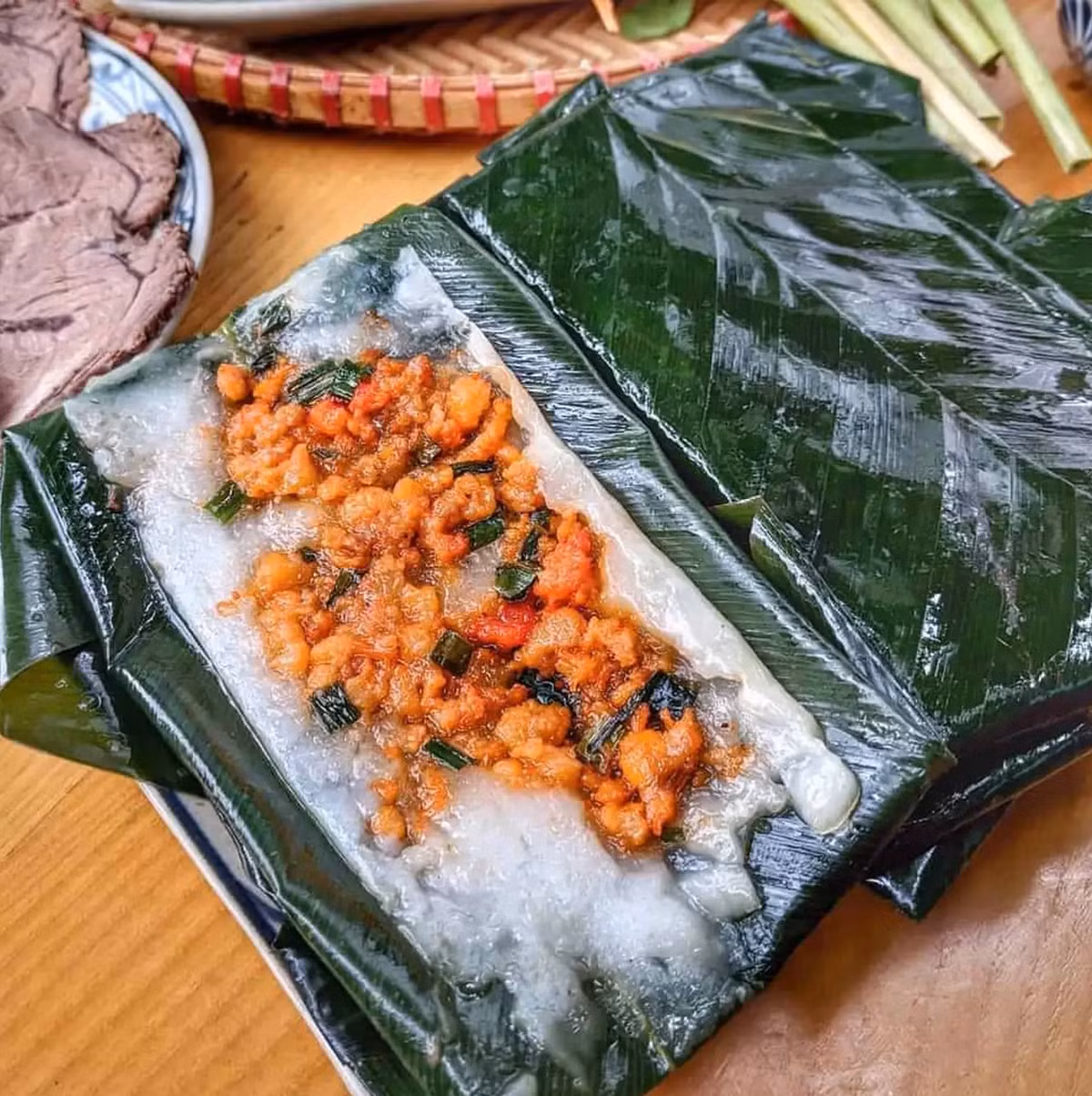 Bánh nậm cũng là một trong những món ăn vặt yêu thích của người dân nơi đây. Chiếc bánh nậm hình chữ nhật, được bọc trong lá dong, với lớp bột trắng ngần điểm xuyến màu tôm hồng bắt mắt. Một bát bánh nậm thường sẽ có thêm chả tôm, chan nước mắm ngọt để làm đậm thêm vị bánh. Ảnh: Traveloka