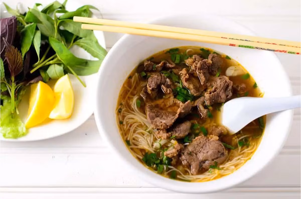 Nhắc đến Huế, người ta nghĩ ngay đến món bún bò cay nồng, đậm đà. Một tô bún bò mang nhiều hương vị khác nhau đến từ các gia vị, rau nêm như mùi sả, nước hầm xương, chanh, tiêu,... Ảnh: Traveloka