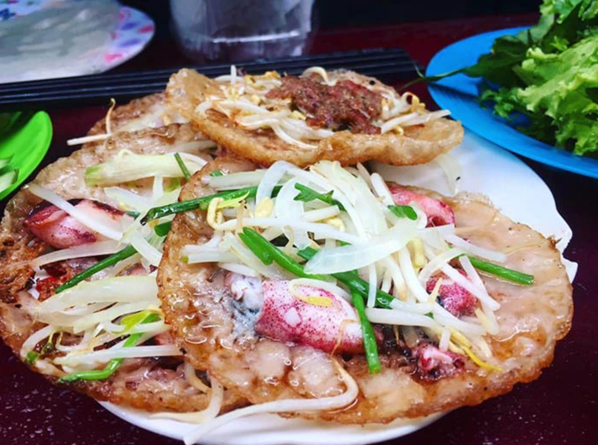 Bánh xèo mực là ón ăn dân dã với lớp vỏ vàng giòn rụm, nhân mực tươi ngon cùng giá đỗ xanh, ăn kèm rau sống và nước chấm chua ngọt.