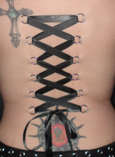 Đây là một trào lưu khá phổ biến của giới Rocker trong thập niên 90. Với kiểu làm đẹp này, người ta sẽ tạo những chiếc khuyên thành hai hàng sau lưng, rồi buộc dây đan chéo nhau sao cho giống những chiếc corset.