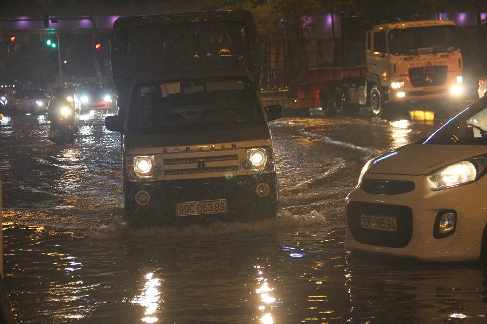 Lượng phương tiện lưu thông khá đông, nhiều phương tiện bất chấp nguy hiểm đi vào vũng nước ngập sâu để băng qua đường.