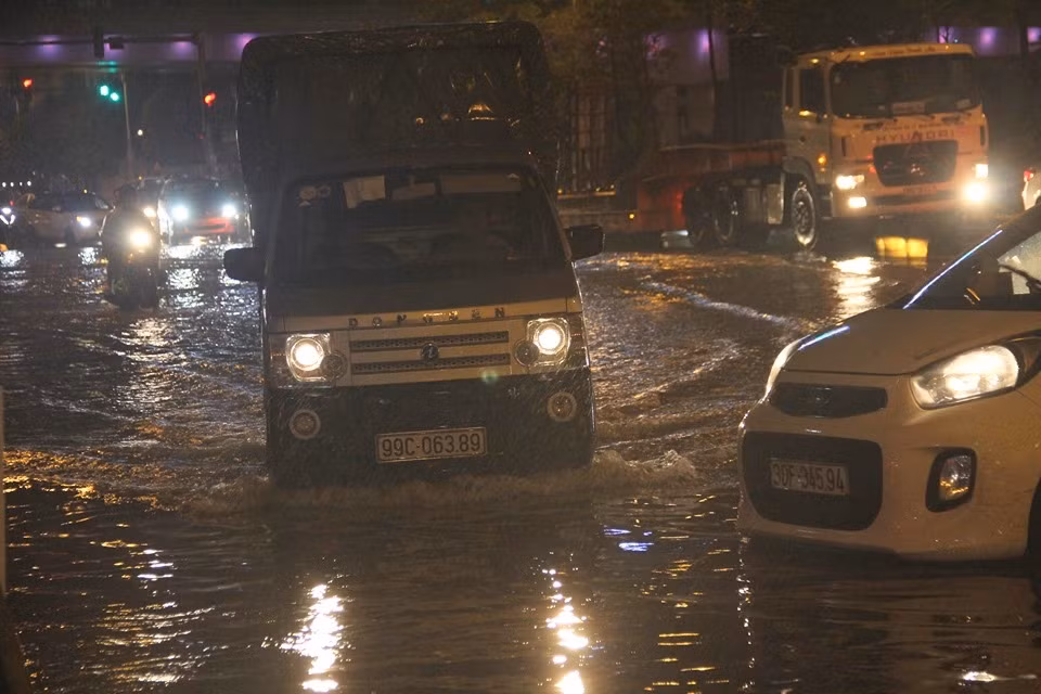 Lượng phương tiện lưu thông khá đông, nhiều phương tiện bất chấp nguy hiểm đi vào vũng nước ngập sâu để băng qua đường.