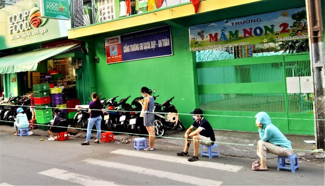 Các cửa hàng tiện lợi trở thành nơi mua sắm trong ngày cách ly xã hội. Trong ảnh là khách hàng ở khu Bến Vân Đồn, quận 4 đang chờ tới lượt của mình bên ngoài cửa hàng tiện lợi.