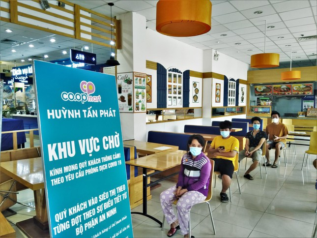 Một số siêu thị vẫn còn hoạt động và là nơi cung ứng sản phẩm thiết yếu, đặc biệt là lương thực thực phẩm cho người dân. Khách hàng phải giữ khoảng cách và tuân thủ sự hướng dẫn của siêu thị. Trong ảnh: Người mua hàng ngồi đợi đến lượt tại Siêu thị Coop Mart quận 7. Mỗi lượt siêu thị chỉ phục vụ 50 khách.