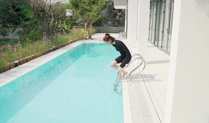 Bể bơi nhà Ngọc Trinh đơn giản với gam màu trắng mà cô yêu thích. Kế bên là khoảng vườn rộng, được trồng nhiều loại hoa, cây ăn quả, tạo khuôn viên mát mẻ, gần gũi với thiên nhiên. Ảnh: Ngoisao.