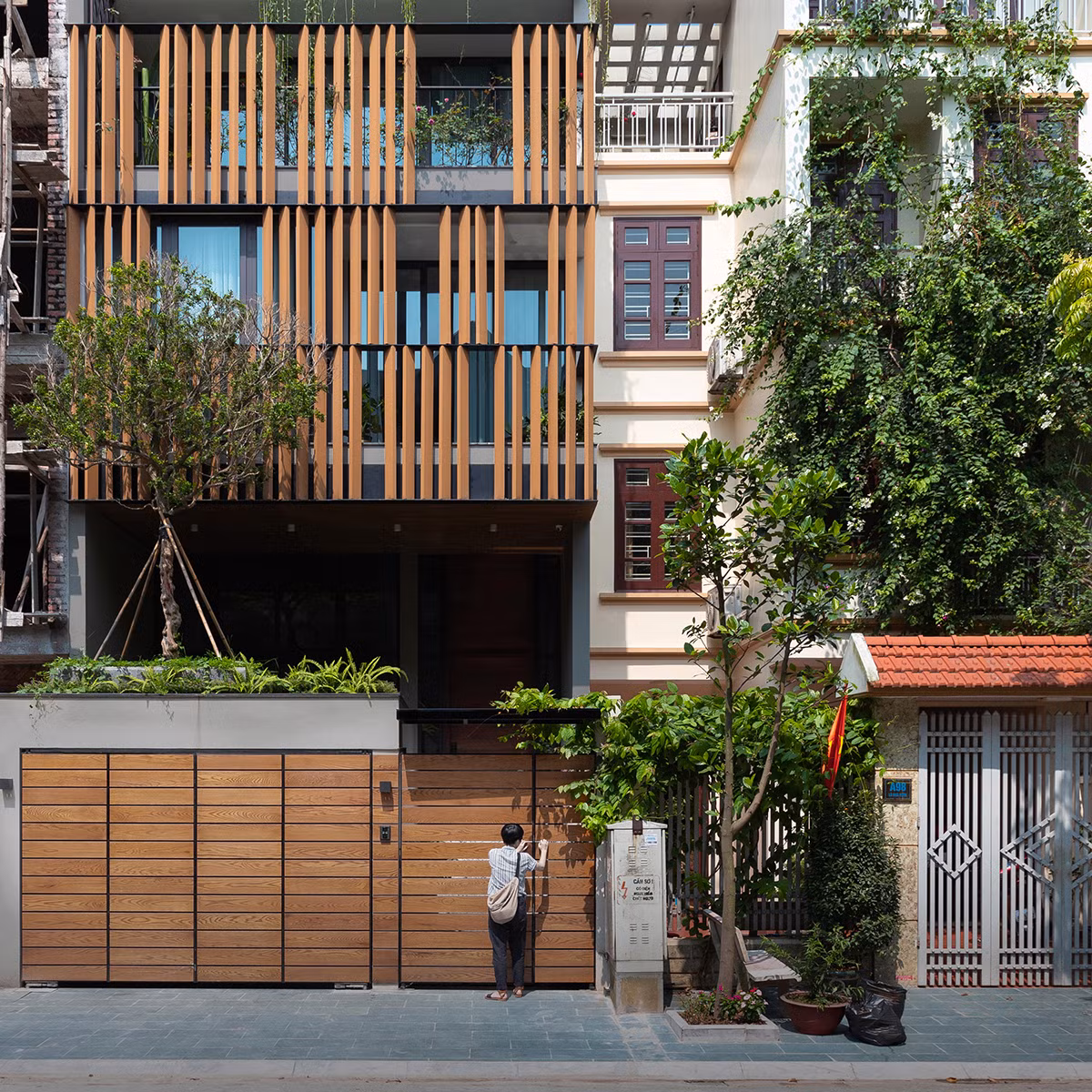 Tọa lạc tại khu đô thị Việt Hưng (Long Biên, Hà Nội), LH House là ngôi nhà hướng Tây sở hữu vẻ ngoài nổi bật với hệ thống lam gỗ mặt tiền rộng lớn. Ảnh: Triệu Chiến.