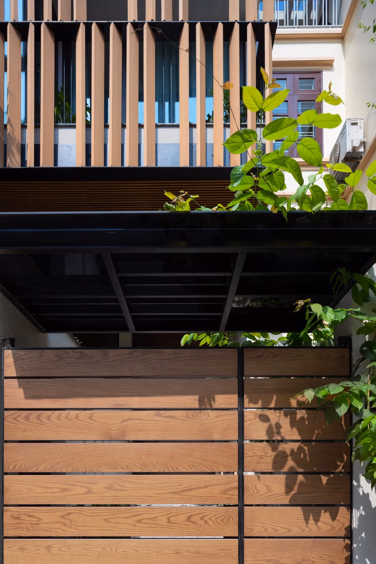 Hệ thống lam gỗ được lắp đặt dọc theo mặt tiền là nhằm mục đích hạn chế bức xạ mặt trời, đồng thời tạo hình cho công trình. Ảnh: Triệu Chiến.