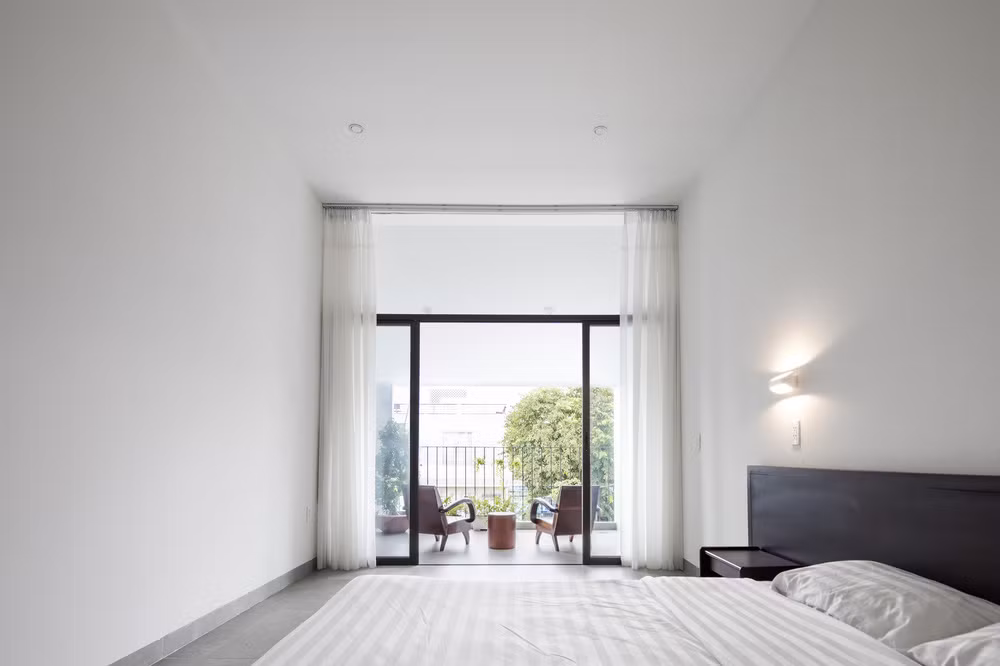 Phòng ngủ chính hạn chế ánh nắng nóng bằng cách sử dụng mái xéo khu ban công.