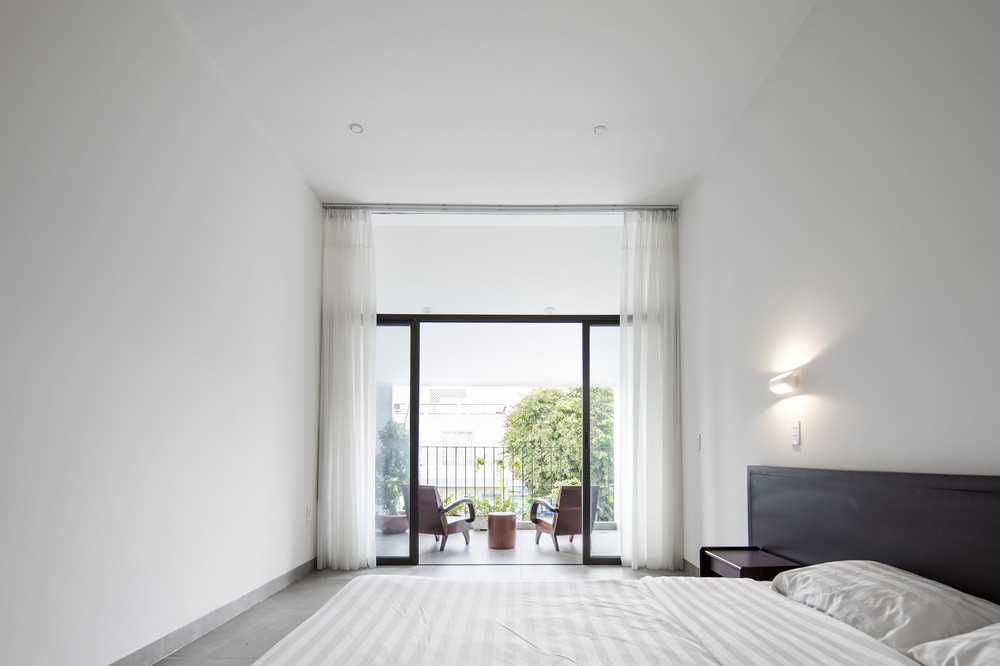 Phòng ngủ chính hạn chế ánh nắng nóng bằng cách sử dụng mái xéo khu ban công.