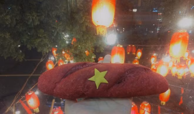 Khách hàng ăn bánh mì “Tổ quốc” không nhân, giá chỉ có 4.000 đồng. Ảnh: Hoahoctro