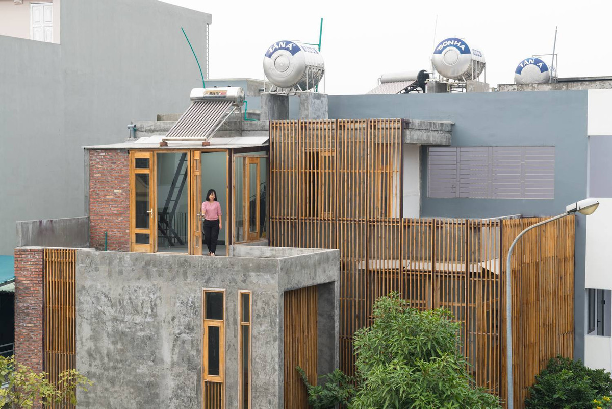 Kết hợp với gạch trần là hệ lam gỗ giống như lớp bảo vệ ngôi nhà khỏi những ánh nhìn của hàng xóm.