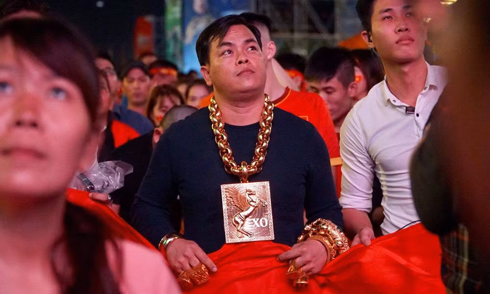 Trần Ngọc Phúc (Phúc XO) nổi tiếng khi đeo nhiều 'vàng' ra phố đi bộ Nguyễn Huệ để xem bóng đá giải AFF Cup. Lúc này anh mang nhiều trang sức khủng, thậm chí còn có 5 vệ sĩ đi theo, có người đỡ vòng cổ cho đỡ nặng. Ảnh: Internet.