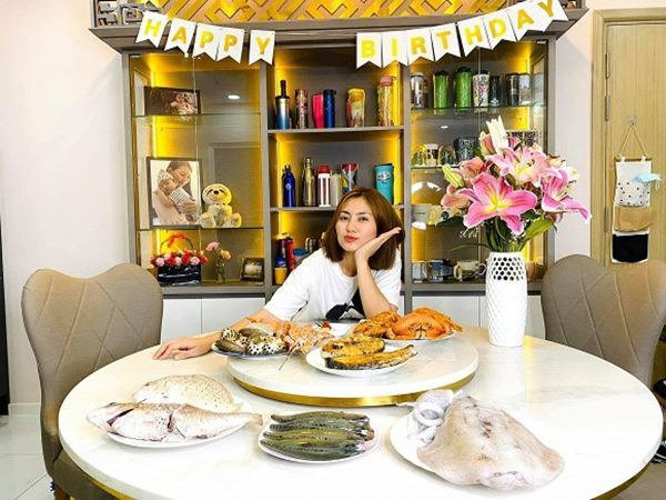 Phòng khách căn hộ nối liền với khu bếp. Tại đây, cô còn thiết kế chiếc bàn tròn lớn. Ảnh: Lao động