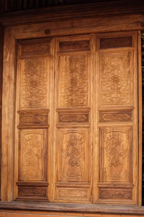 Toàn bộ chánh điện được làm bằng gỗ. Cánh cửa cũng có hoa văn độc đáo. Ảnh: Dân Việt.
