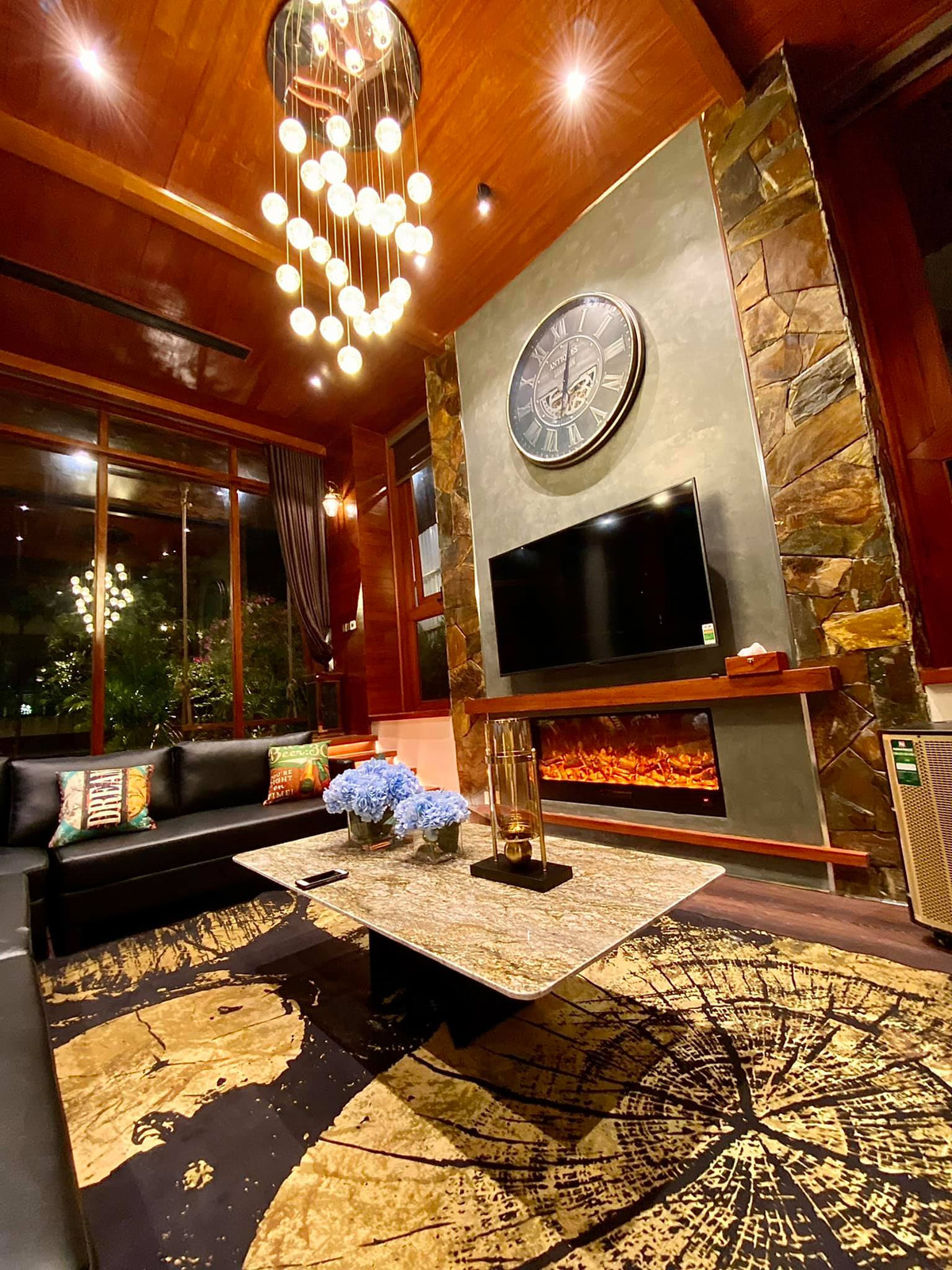 Điểm nhấn đặc biệt là bộ sô pha âm sàn hình bán nguyệt vây quanh một chiếc chiếc lò sưởi, nơi chủ khách có thể ngồi quây quần vào những ngày đông lạnh giá.