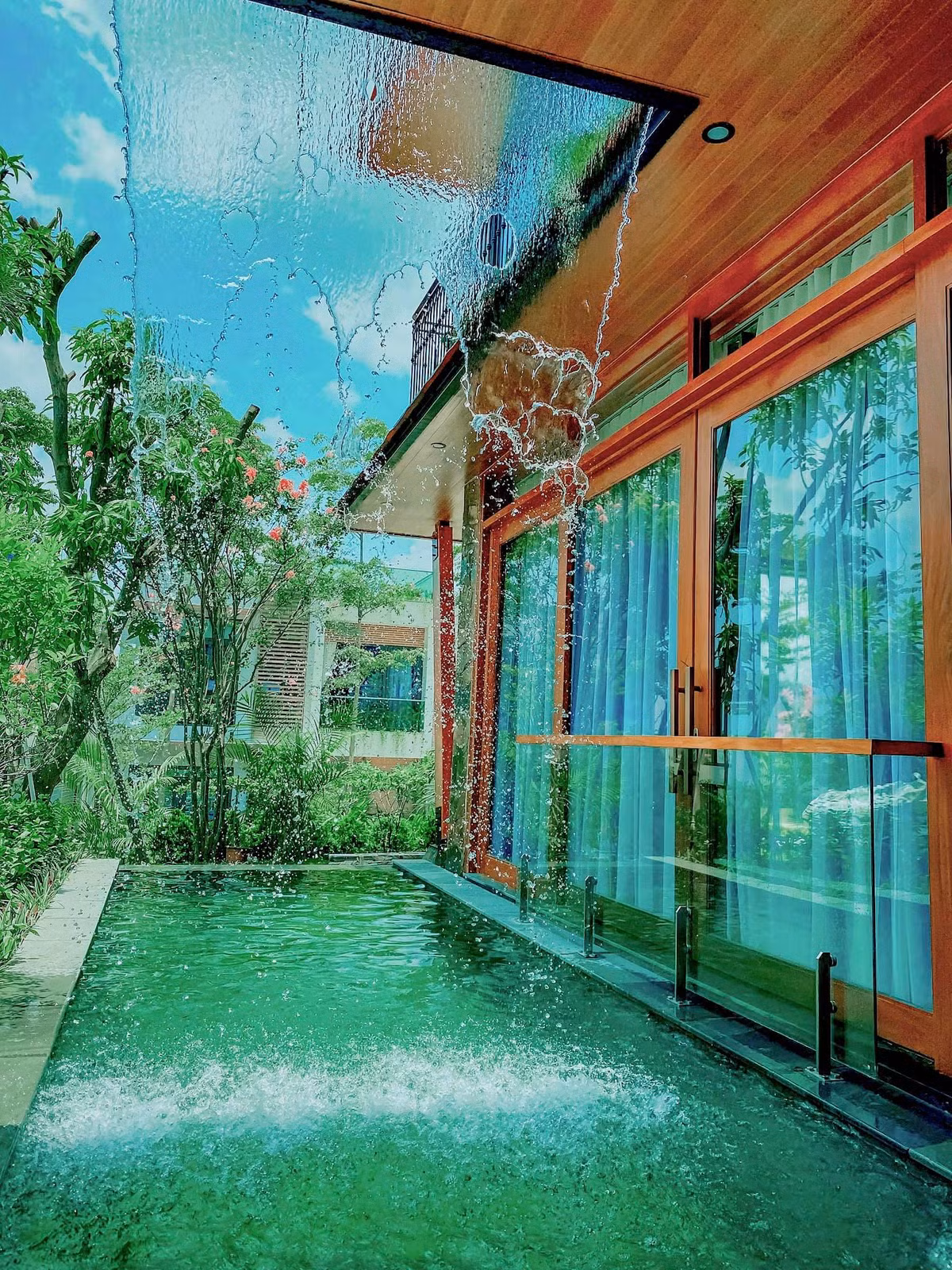 Bể bơi với tấm màn nước đổ xuống như ngọn thác hùng vĩ.