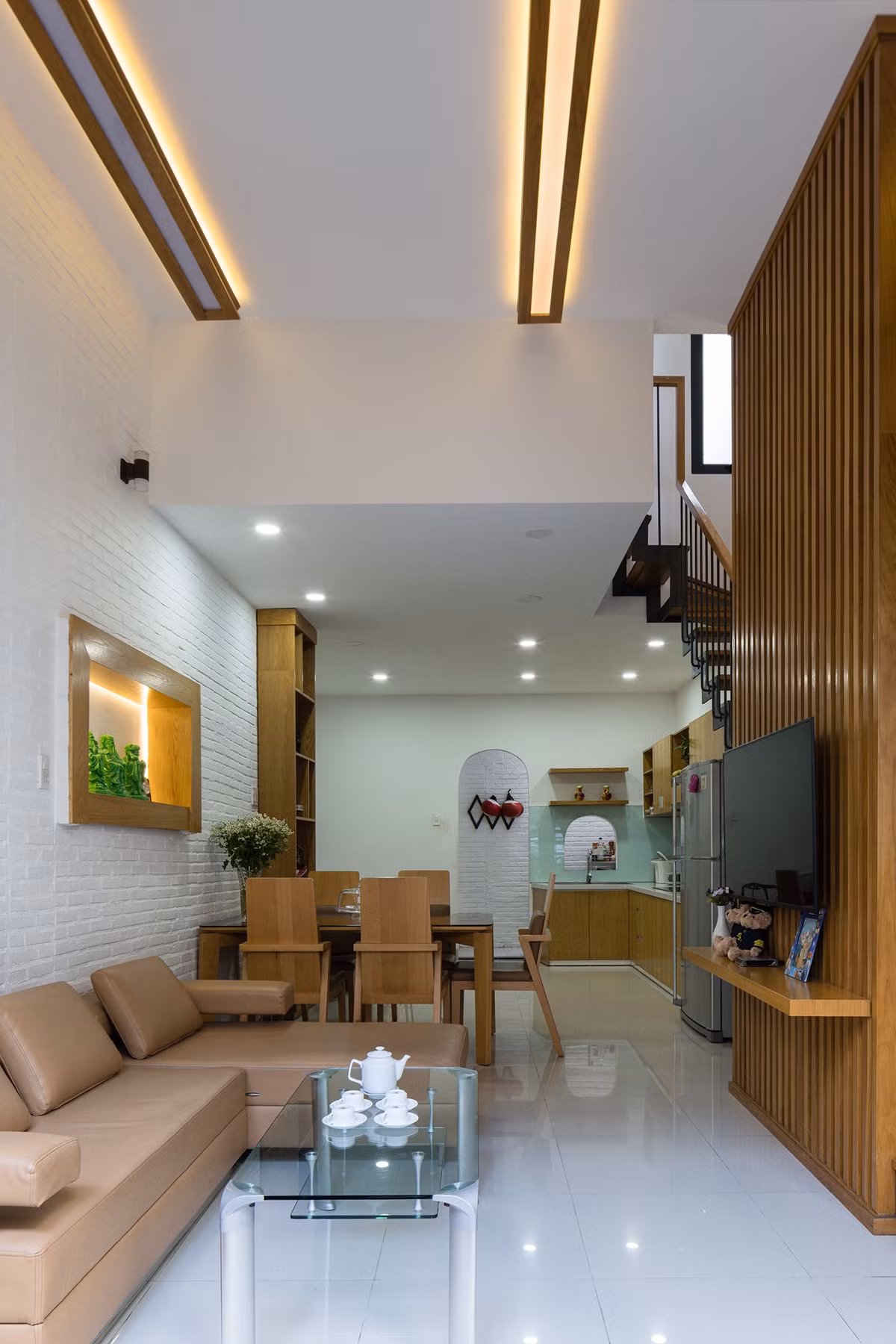 Chiều ngang nhà chỉ 4m nên bên trong công trình, nhóm thiết kế sử dụng bố cục đơn giản. Không gian sinh hoạt nằm trước và sau nhà, ở giữa là cầu thang kết hợp thông tầng lấy sáng và lưu thông không khí.