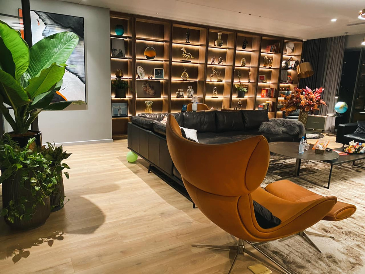 Phòng khách rộng, có tủ gỗ lớn để trưng bày đồ lưu niệm.