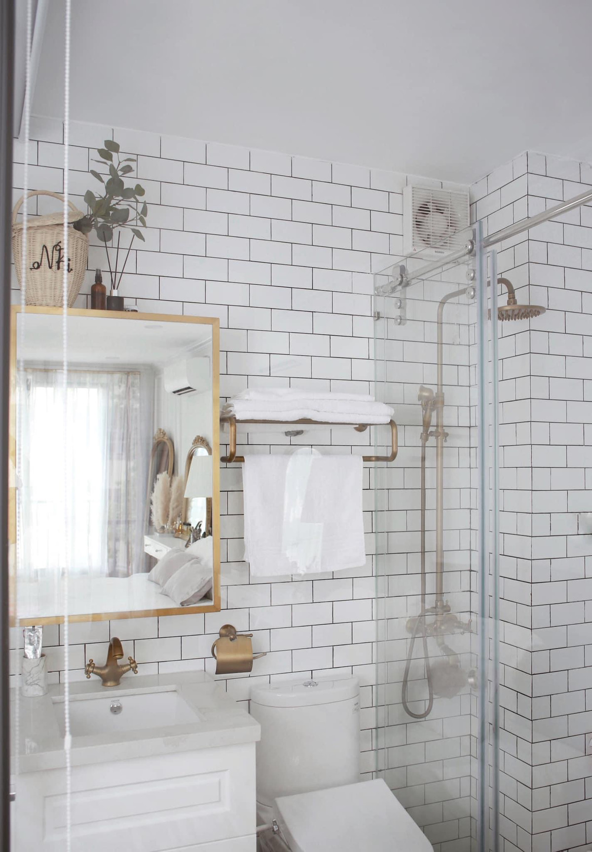 Ngoài tông trắng, nội thất phòng tắm còn được nhấn nhá thêm màu vàng đồng bắt mắt.