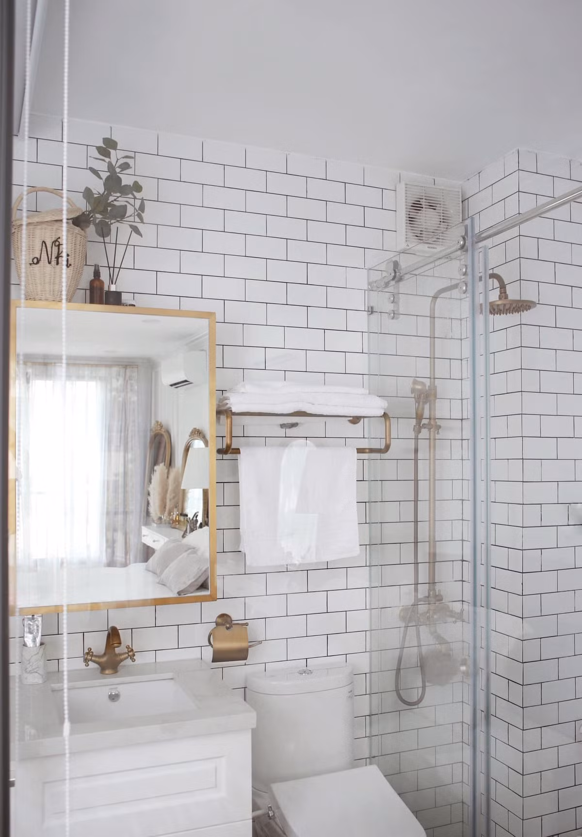 Ngoài tông trắng, nội thất phòng tắm còn được nhấn nhá thêm màu vàng đồng bắt mắt.