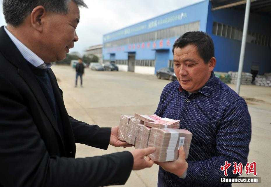 Một đại gia Trung Quốc khác cũng gây sốt khi phát những cục tiền thưởng Tết dày cộp cho 90 nông dân làm việc tại doanh nghiệp của mình. Ảnh: China News.