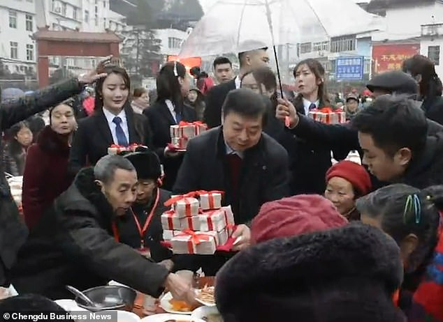 Ông Zheng còn trao rất nhiều quà tặng tiền mặt - trị giá từ 2.000 đến 60.000 nhân dân tệ - cho những người dân nơi đây. Các bó tiền quá dày không thể nhét vừa trong phong bì đỏ truyền thống, vì vậy mỗi bó tiền được buộc bằng một dải ruy băng đỏ. Ảnh: Hongxing News.