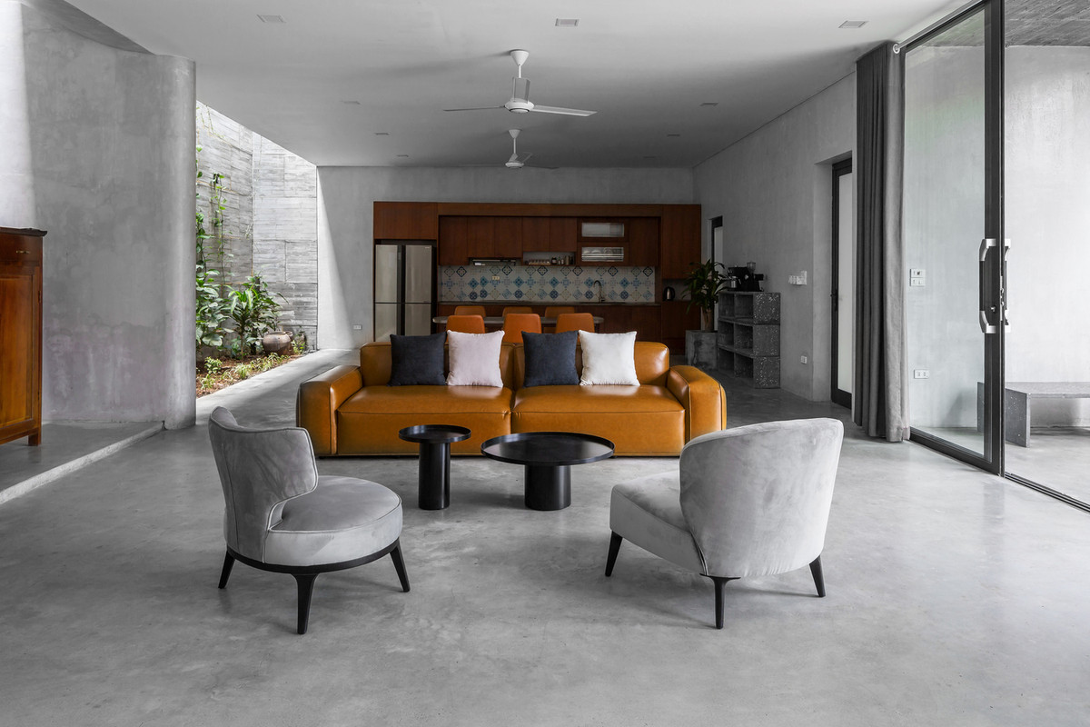 Với sự yêu thích bê tông của gia chủ, nhóm thiết kế chọn vật liệu hoàn thiện nhà chủ yếu là bê tông với bề mặt nhám, gỗ màu hạt dẻ giúp không gian trở nên ấm cúng hơn.